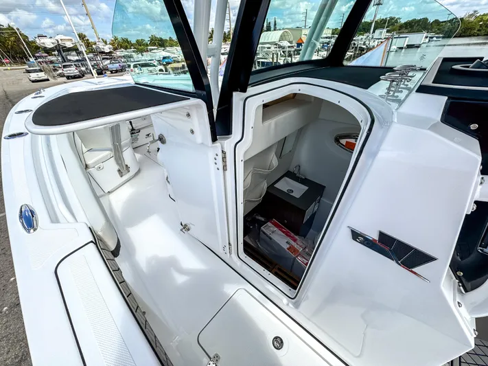  Yacht Photos Pics 2025 Wellcraft 302 Fisherman boat interior, featuring sleek white design and storage compartment.