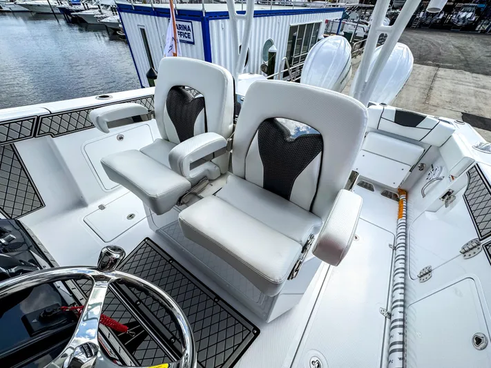  Yacht Photos Pics 2025 Wellcraft 302 Fisherman boat interior with dual white seats at marina.