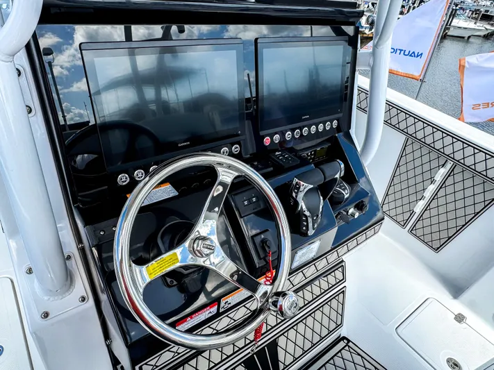  Yacht Photos Pics 2025 Wellcraft 302 Fisherman boat dashboard with dual screens and steering wheel.