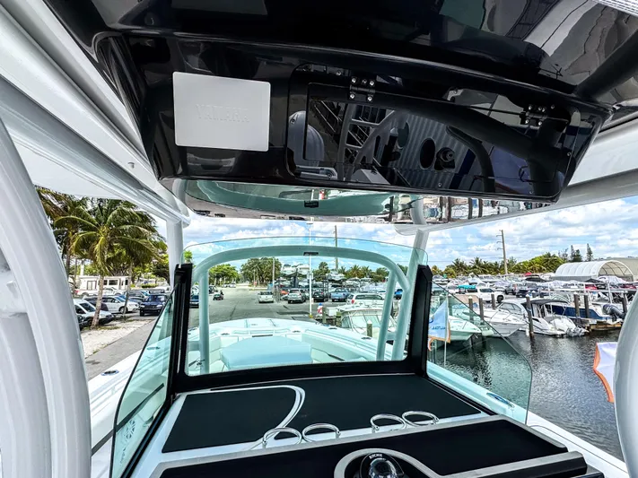  Yacht Photos Pics 2025 Wellcraft 302 Fisherman boat interior, showcasing helm and marina view.