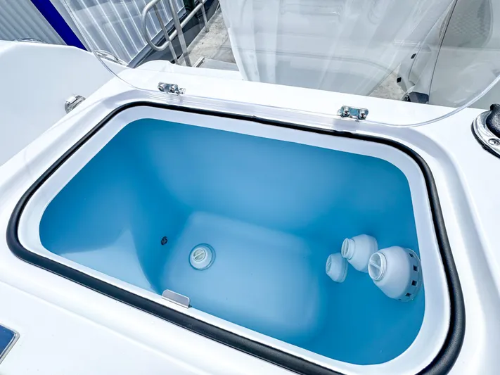  Yacht Photos Pics Livewell compartment on 2025 Wellcraft 302 Fisherman boat, featuring a blue interior.