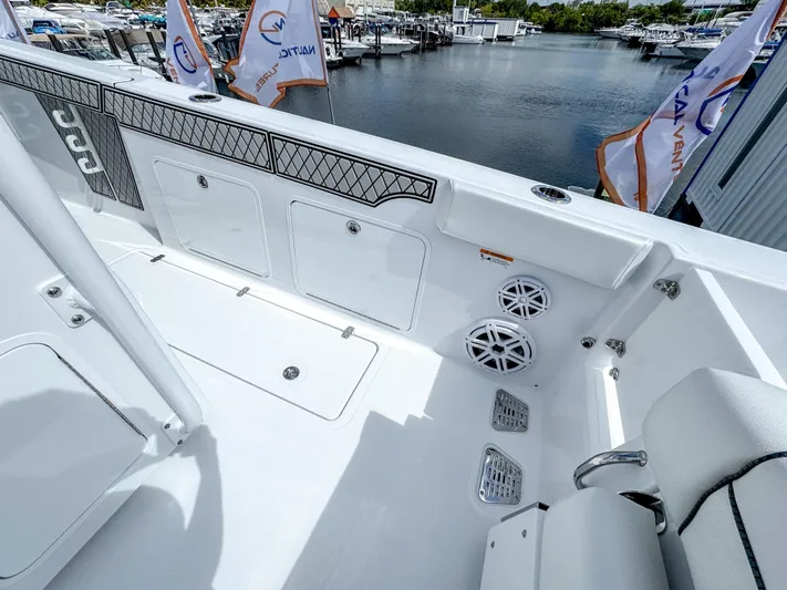  Yacht Photos Pics 2025 Wellcraft 302 Fisherman boat interior with storage compartments and speakers, docked at marina.