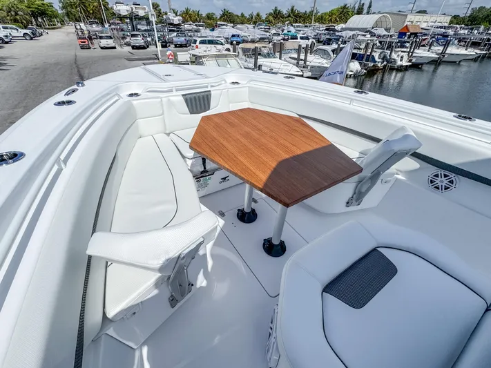  Yacht Photos Pics 2025 Wellcraft 302 Fisherman boat with white seating and wooden table in marina setting.