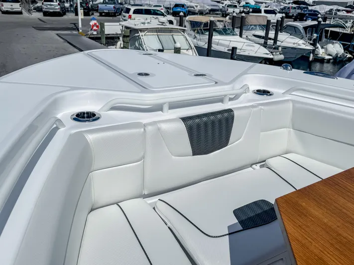  Yacht Photos Pics 2025 Wellcraft 302 Fisherman boat interior with white seating and wood accents at a marina.