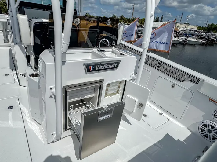  Yacht Photos Pics 2025 Wellcraft 302 Fisherman boat interior with open storage compartments at a marina.