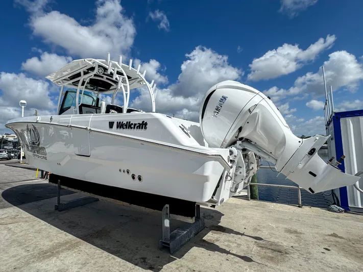 Yacht Photos Pics 2025 Wellcraft 302 Fisherman boat on display under a bright blue sky.