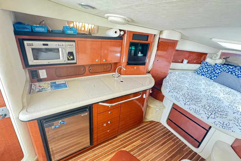 Yacht Photos Pics 2005 Sea Ray 340 Sundancer interior with kitchenette and cozy sleeping area.