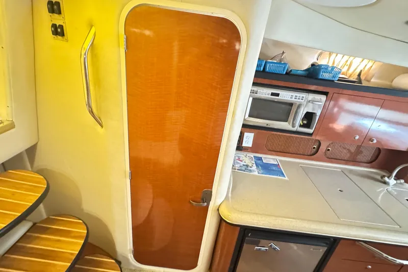  Yacht Photos Pics 2005 Sea Ray 340 Sundancer interior with kitchenette and wooden door.