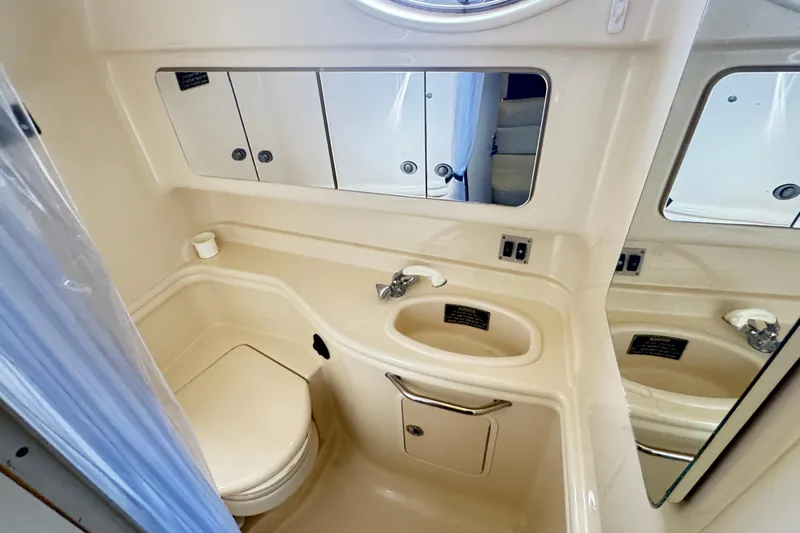  Yacht Photos Pics 2005 Sea Ray 340 Sundancer bathroom with sink, toilet, and mirrored cabinets.