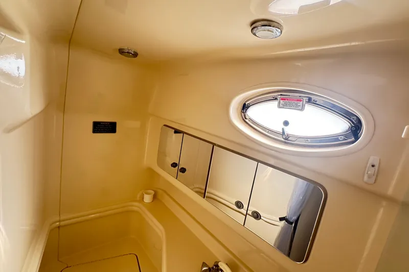  Yacht Photos Pics 2005 Sea Ray 340 Sundancer bathroom with oval window and mirrored cabinet.