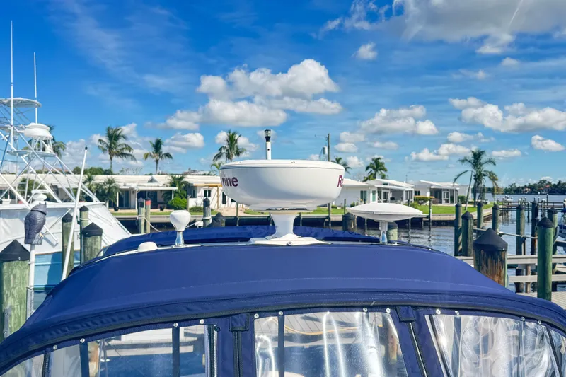  Yacht Photos Pics 2005 Sea Ray 340 Sundancer docked, featuring radar equipment, with palm trees and blue sky background.