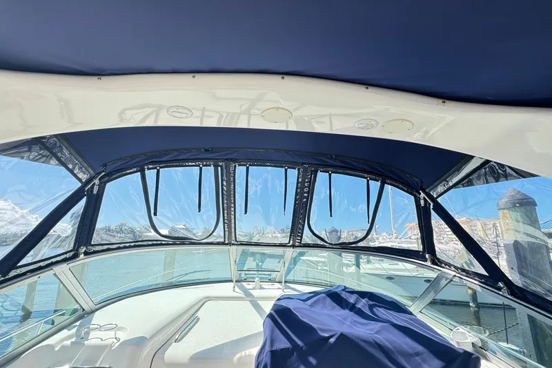  Yacht Photos Pics 2005 Sea Ray 340 Sundancer cockpit with blue canopy and clear windows, docked at marina.