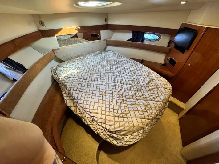 Full House Yacht Photos Pics Cozy bedroom in 2006 Meridian 368 Motoryacht with bed, TV, and porthole window.