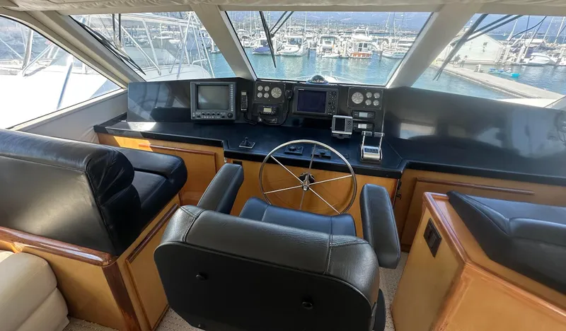 Gitana Yacht Photos Pics 2000 Viking Enclosed Flybridge helm with leather seating and navigation equipment.