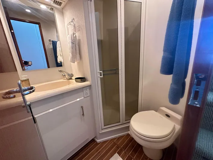 Gitana Yacht Photos Pics Bathroom interior of 2000 Viking Enclosed Flybridge yacht with shower, sink, and toilet.