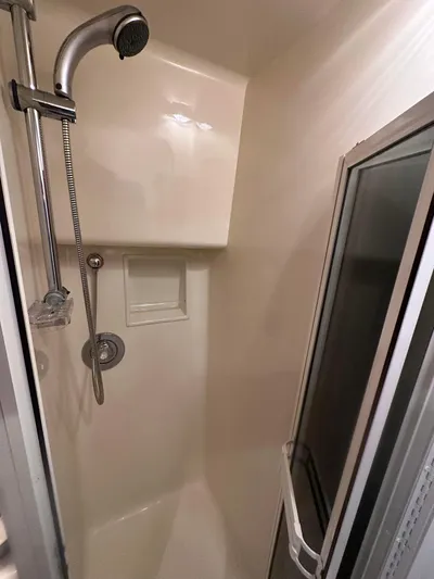 Gitana Yacht Photos Pics Shower area in 2000 Viking Enclosed Flybridge yacht, featuring handheld showerhead and glass door.