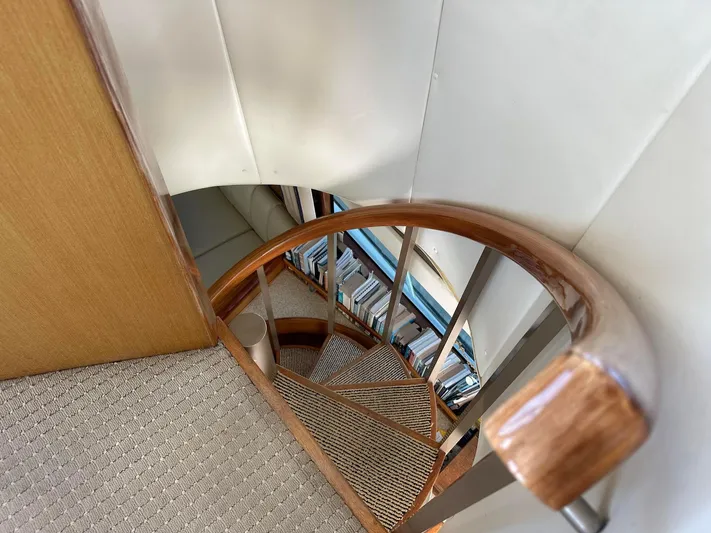 Gitana Yacht Photos Pics Staircase inside 2000 Viking Enclosed Flybridge yacht with wooden handrail and carpeted steps.
