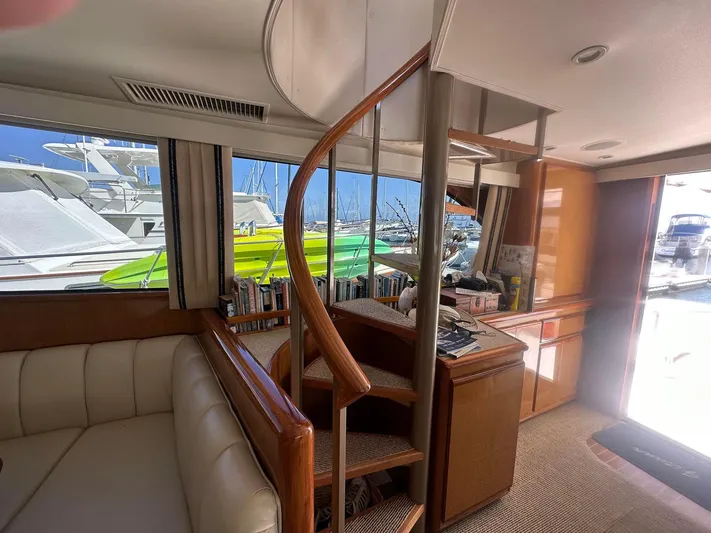Gitana Yacht Photos Pics Interior of 2000 Viking Enclosed Flybridge yacht with spiral staircase and marina view.