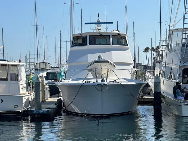 Gitana Yacht Photos Pics 2000 Viking Enclosed Flybridge yacht docked at marina, surrounded by other boats.