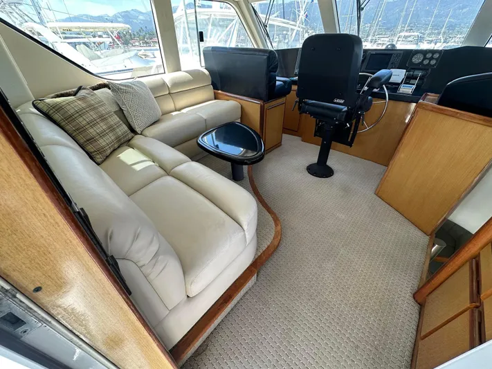 Gitana Yacht Photos Pics Luxurious interior of 2000 Viking Enclosed Flybridge yacht with plush seating and helm.