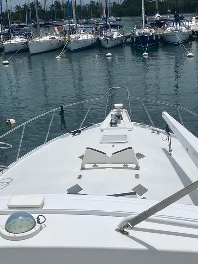  Yacht Photos Pics 2005 Hatteras 50 Convertible yacht docked in a marina with sailboats.