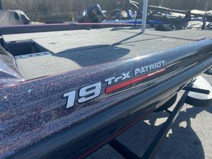 2025 Triton 19 TrX Patriot boat with glitter finish, parked outdoors.