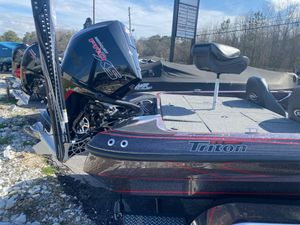 2025 Triton 19 TrX Patriot boat with Mercury Pro XS engine, parked outdoors.