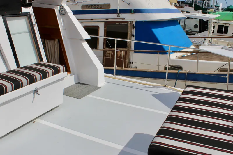 Rc Venture Yacht Photos Pics 1989 Ocean Alexander 44 yacht deck with striped seating, docked beside another boat.
