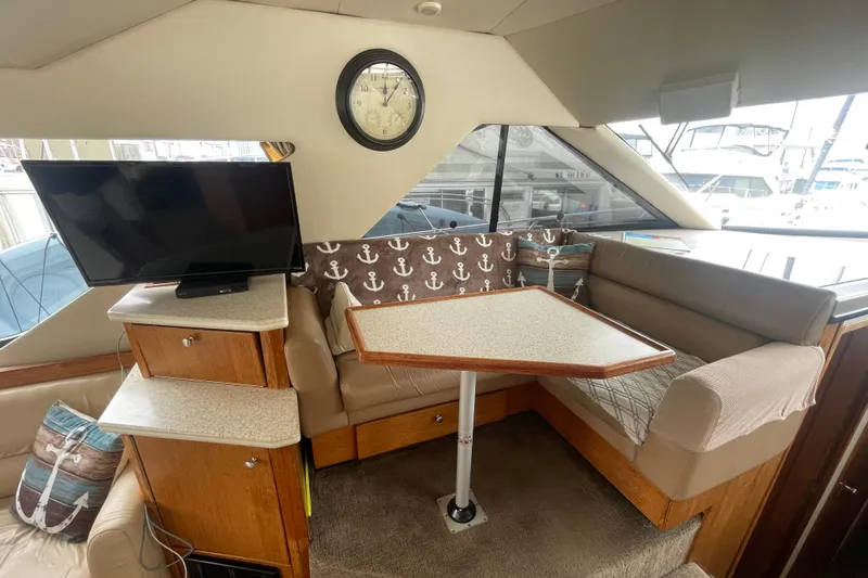  Yacht Photos Pics 1999 Bayliner 3988 Motoryacht interior with TV, clock, and dining area.