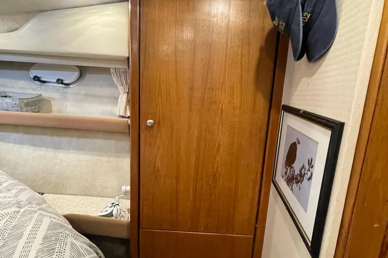  Yacht Photos Pics Interior of 1999 Bayliner 3988 Motoryacht with wooden cabinet and framed artwork.