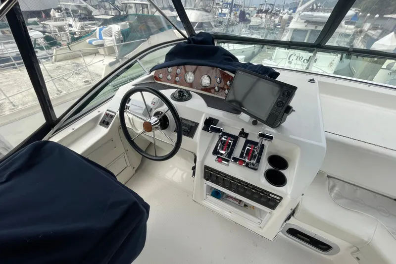  Yacht Photos Pics 1999 Bayliner 3988 Motoryacht helm with steering wheel, controls, and navigation equipment.