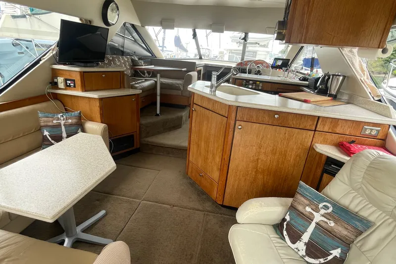  Yacht Photos Pics 1999 Bayliner 3988 Motoryacht interior with cozy seating, wooden cabinetry, and modern amenities.