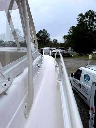 Soggy Dollars Yacht Photos Pics 2007 Intrepid 35 Walkaround boat side view with trees and vehicles in the background.