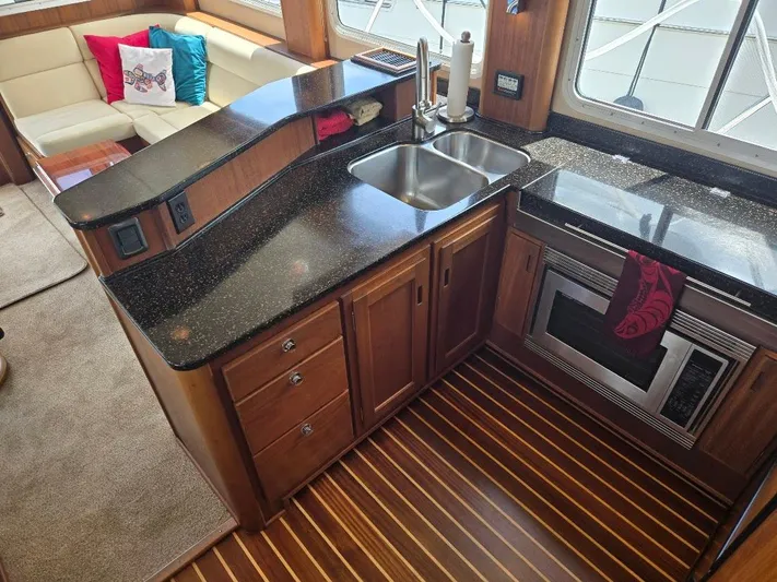 Chinook Yacht Photos Pics Luxurious kitchen in 2010 American Tug 49 Limited yacht with modern appliances and wood flooring.