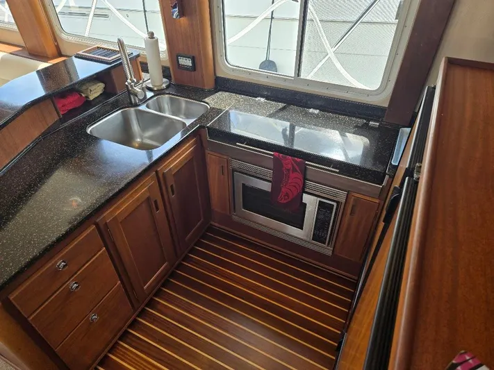 Chinook Yacht Photos Pics 2010 American Tug 49 Limited kitchen with wood cabinetry, dual sink, and microwave.