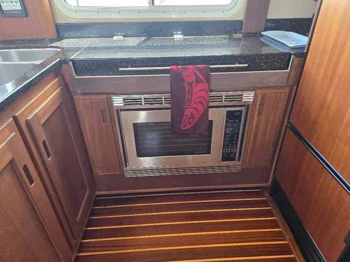 Chinook Yacht Photos Pics Kitchen area of a 2010 American Tug 49 Limited with wood flooring and modern appliances.