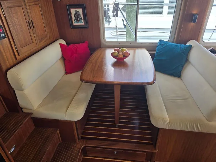 Chinook Yacht Photos Pics Cozy dining area in 2010 American Tug 49 Limited with cushioned seating and wooden table.