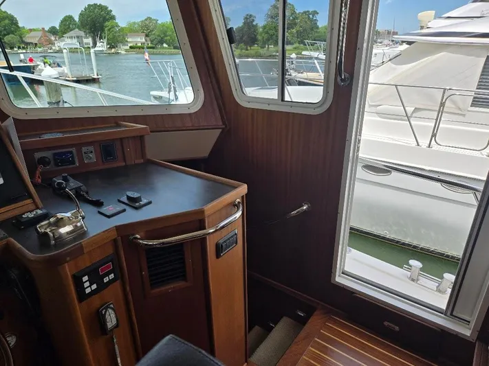 Chinook Yacht Photos Pics Interior view of 2010 American Tug 49 Limited, showcasing helm and marina through windows.