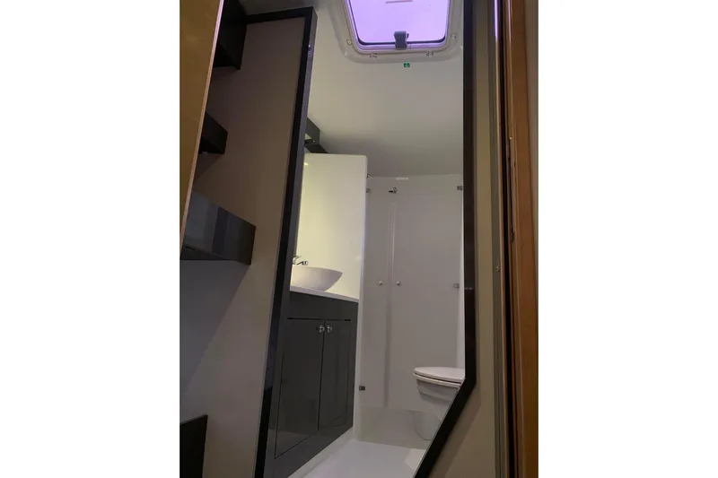 Freckled Parrot Yacht Photos Pics Bathroom interior of 2015 Fountaine Pajot Helia 44 catamaran, featuring modern fixtures and skylight.