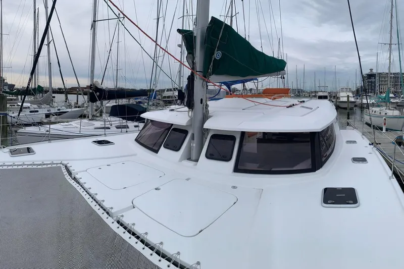 Freckled Parrot Yacht Photos Pics 2015 Fountaine Pajot Helia 44 catamaran docked in a marina, featuring sleek design and spacious deck.