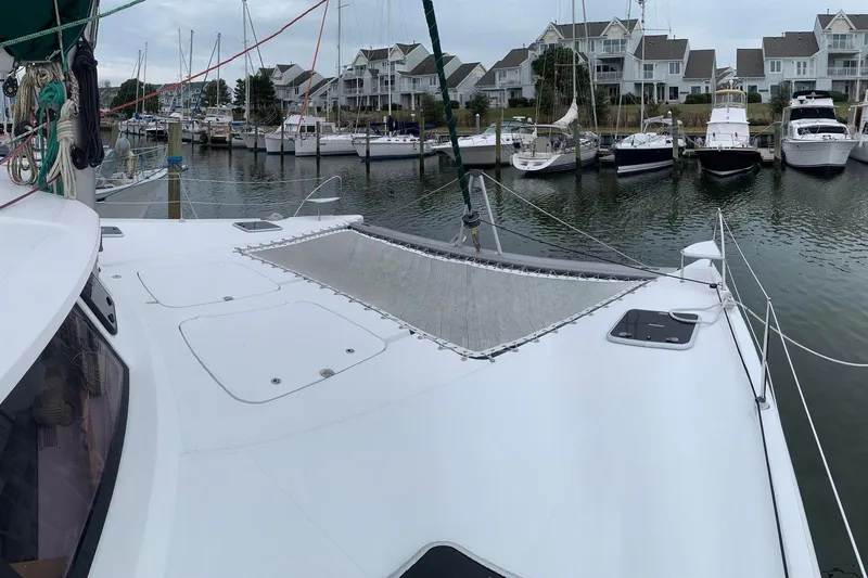 Freckled Parrot Yacht Photos Pics 2015 Fountaine Pajot Helia 44 catamaran docked in a marina with waterfront homes.