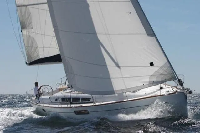  Yacht Photos Pics 2009 Jeanneau Sun Odyssey 44i sailing on open water with full sails.