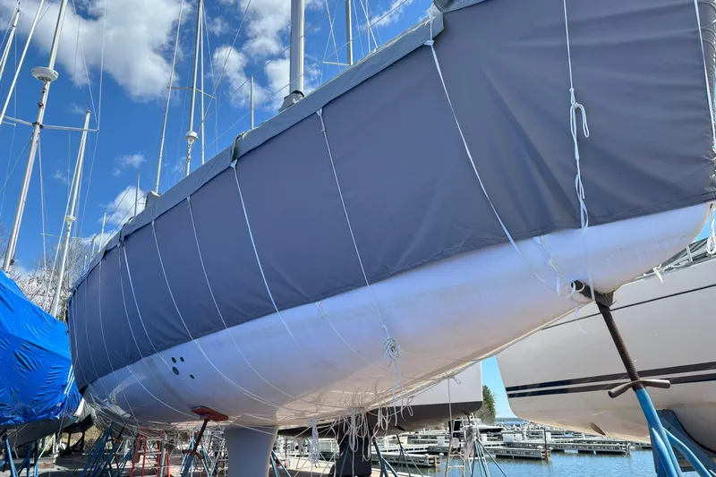  Yacht Photos Pics 2009 Jeanneau Sun Odyssey 44i sailboat covered, docked at marina under blue sky.