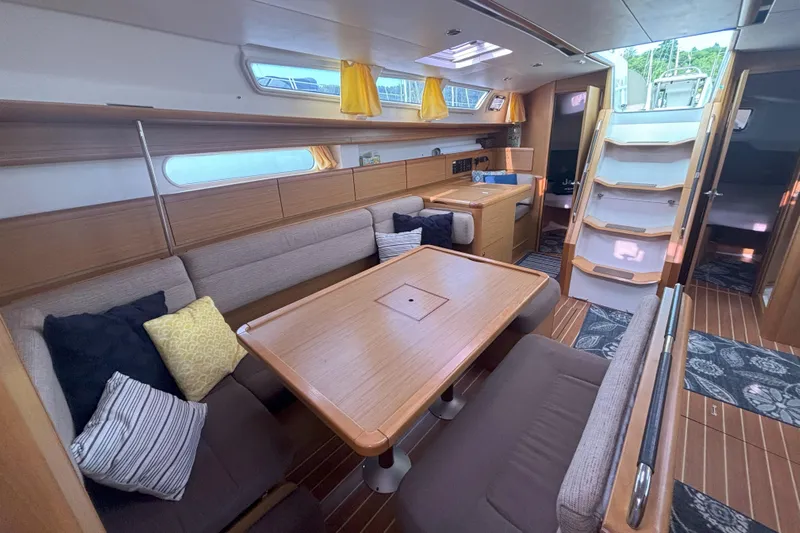  Yacht Photos Pics Interior of 2009 Jeanneau Sun Odyssey 44i sailboat with cozy seating and wooden finishes.