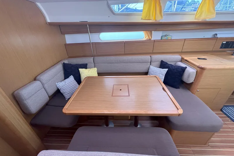  Yacht Photos Pics Interior of 2009 Jeanneau Sun Odyssey 44i yacht with cozy seating and wooden table.