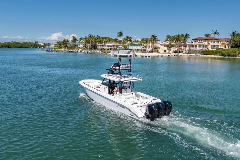 Papa Roach III Yacht Photos Pics 2025 Everglades 375 Center Console boat cruising near luxury waterfront homes.