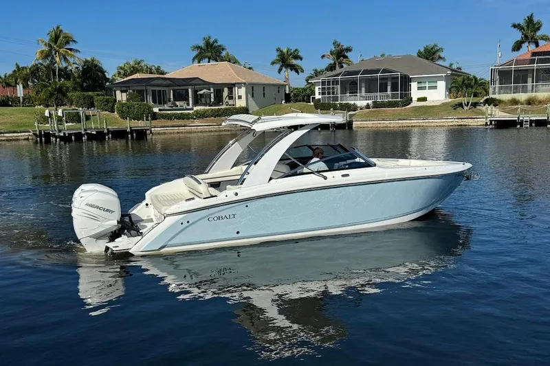  Yacht Photos Pics 2018 Cobalt 30SC boat on calm water near waterfront homes.