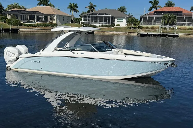  Yacht Photos Pics 2018 Cobalt 30SC boat on calm water, with waterfront homes in the background.