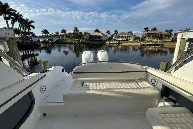  Yacht Photos Pics 2018 Cobalt 30SC boat with luxurious seating, docked by a scenic waterfront with palm trees.