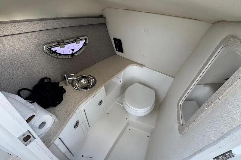  Yacht Photos Pics 2018 Cobalt 30SC boat interior with compact bathroom, sink, and window.